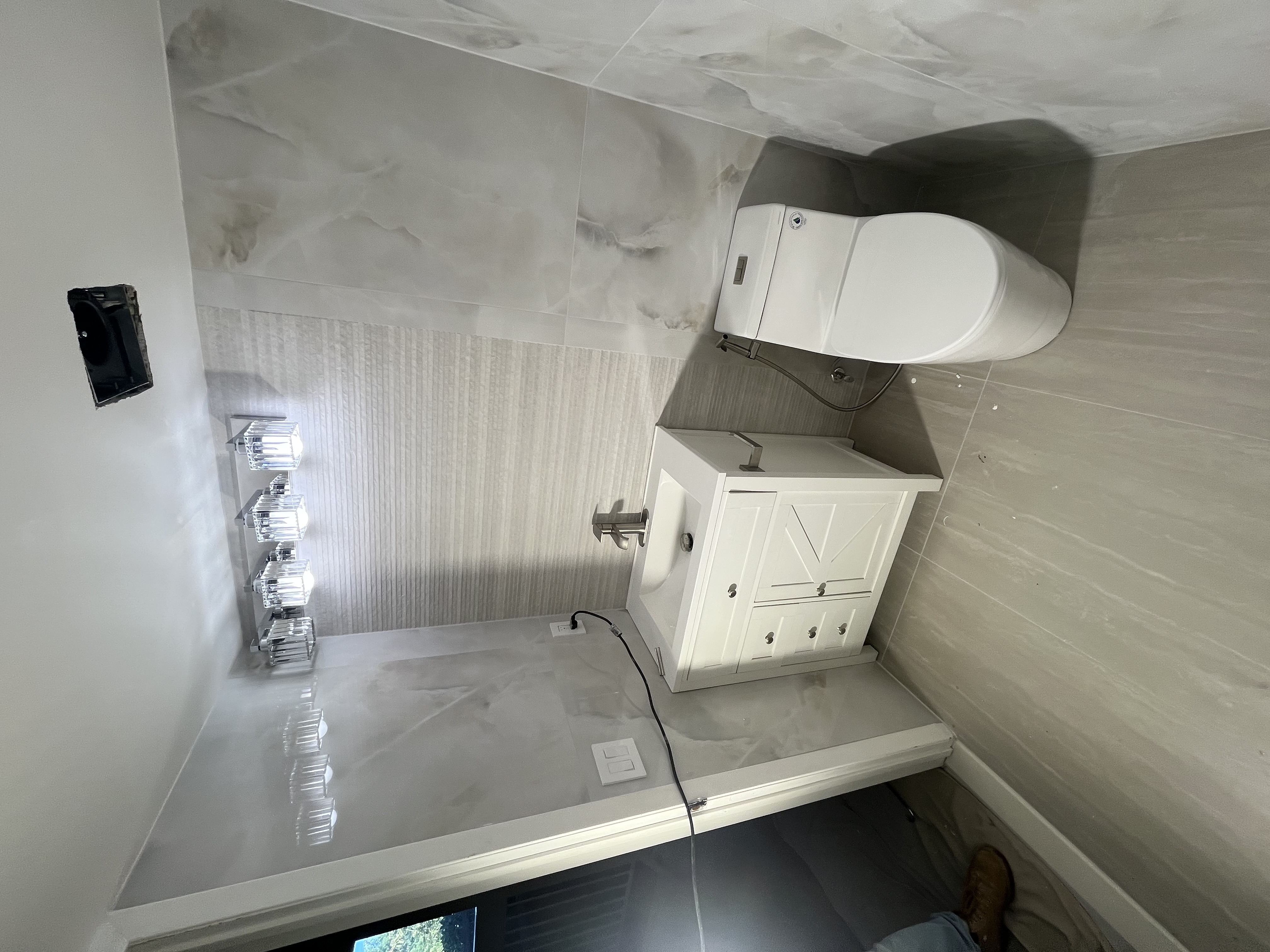 Modern bath with brass hardware and sconce lighting