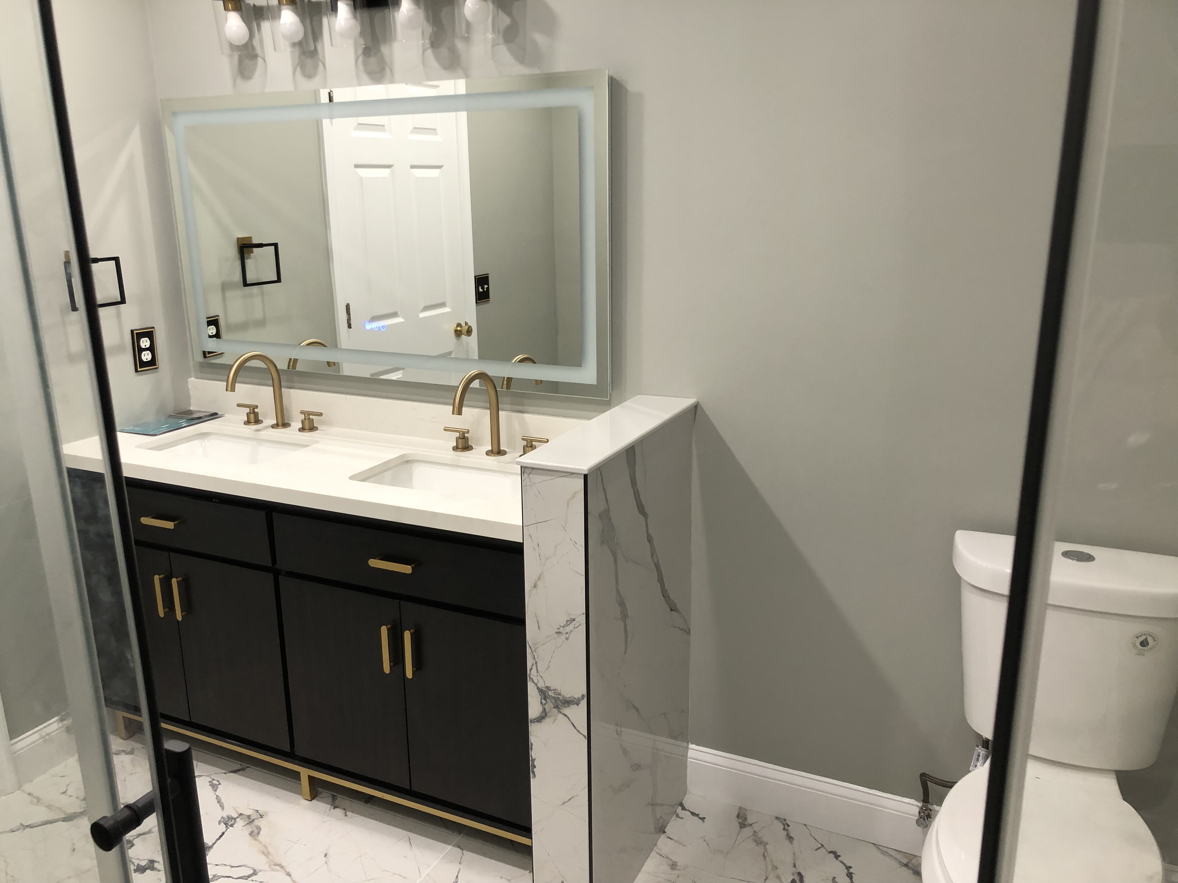 Modern bath with brass hardware and sconce lighting